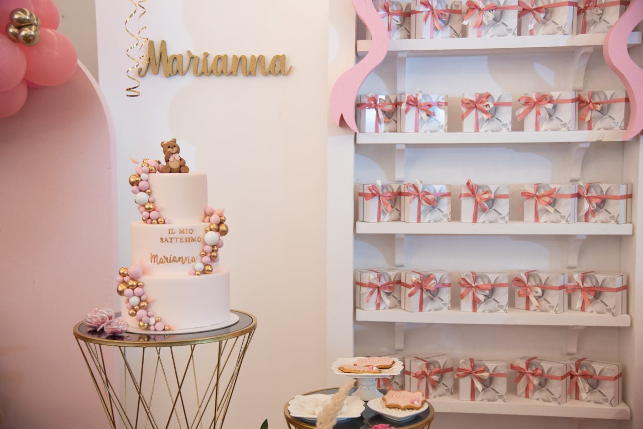 Elegant decor for a baptism celebration featuring a cake and gift boxes in a stylish setting.